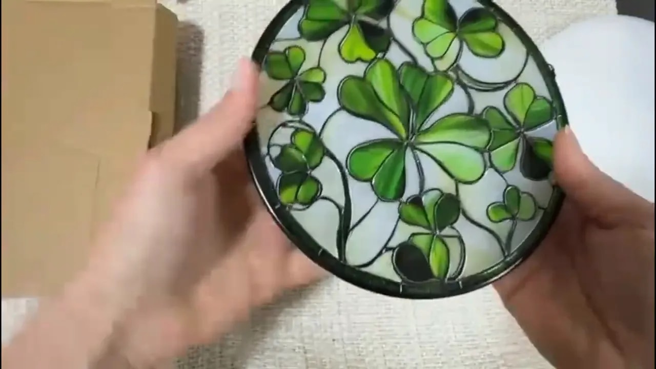 Close-up of stained glass lucky clover sun catcher showing green clover leaf design